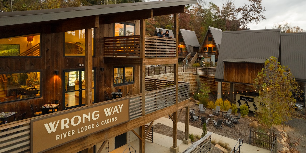 Close view of Wrong Way River Lodge with A-frame cabins in the background.